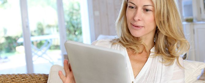 Beautiful mature woman using electronic tablet