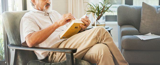 Relax, book and a senior asian man reading on a chair in the living room of his home during retirement. Study, learning and elderly person pensioner in his house alone for a literature leisure hobby.