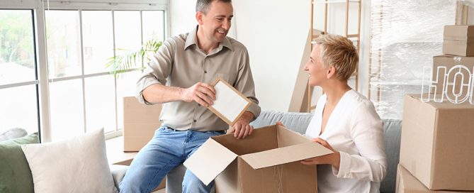 Mature couple packing things in room on moving day