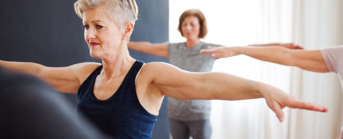 Group of senior people doing exercise in community center club.